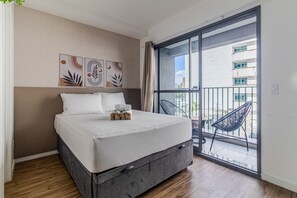 A bedroom with a bed, a window, and a balcony with a chair. - Your Code Liberdade (São Paulo)
