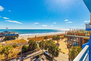 A beachside hotel with a view of the ocean, a lifeguard tower, and a boardwalk with palm trees. - Yachtsman S405 1 BR (Myrtle Beach)