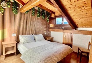 A wooden interior with a bed, nightstands, and a window with the word 'LOVE' on it. - Val di Sole Apartment, with pets allowed (Trentino-Alto Adige)