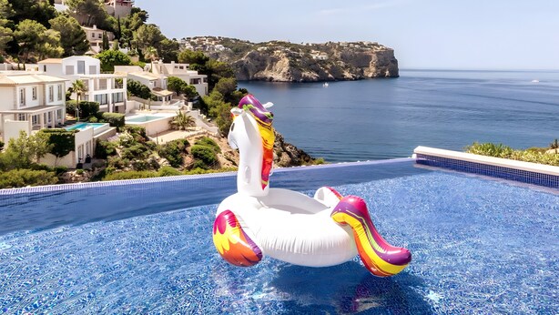 Una piscina con un flotador de flamenco inflable y de colores.