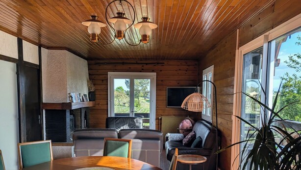A wooden interior with a dining area, sofa, and large windows. - T3 fully equipped - short stay / mobility lease - balcony overlooking the vineyards (Prignac-et-Marcamps)