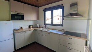 A kitchen with wooden ceiling, a window, a microwave, and a refrigerator. - T3 fully equipped - short stay / mobility lease - balcony overlooking the vineyards (Prignac-et-Marcamps)