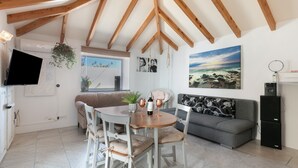 A cozy living area with a dining table, chairs, a sofa, and a television. - Vacation Home 'Casa Dell Anna' with Sea View, Wi-Fi and Air Conditioning (Icod de los Vinos)