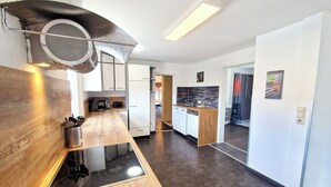 Een moderne keuken met een houten aanrecht, een ingebouwde kookplaat en een magnetron.