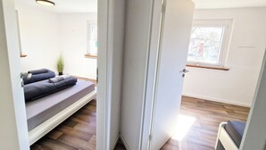 Een moderne kamer met een ingebouwde bank, een deur naar een andere kamer en een raam met uitzicht.