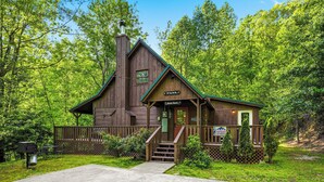 A rustic cabin with a porch, steps, and a sign indicating '300 Party Per Day.' - Cozy* Secluded*Firepit*Hot Tub*Seeps 7 (Pigeon Forge)