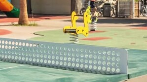 Un'area giochi con uno scivolo giallo e un fondo verde.