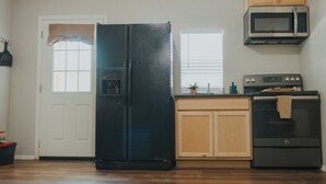 A kitchen with a refrigerator, oven, microwave, and wooden cabinets.