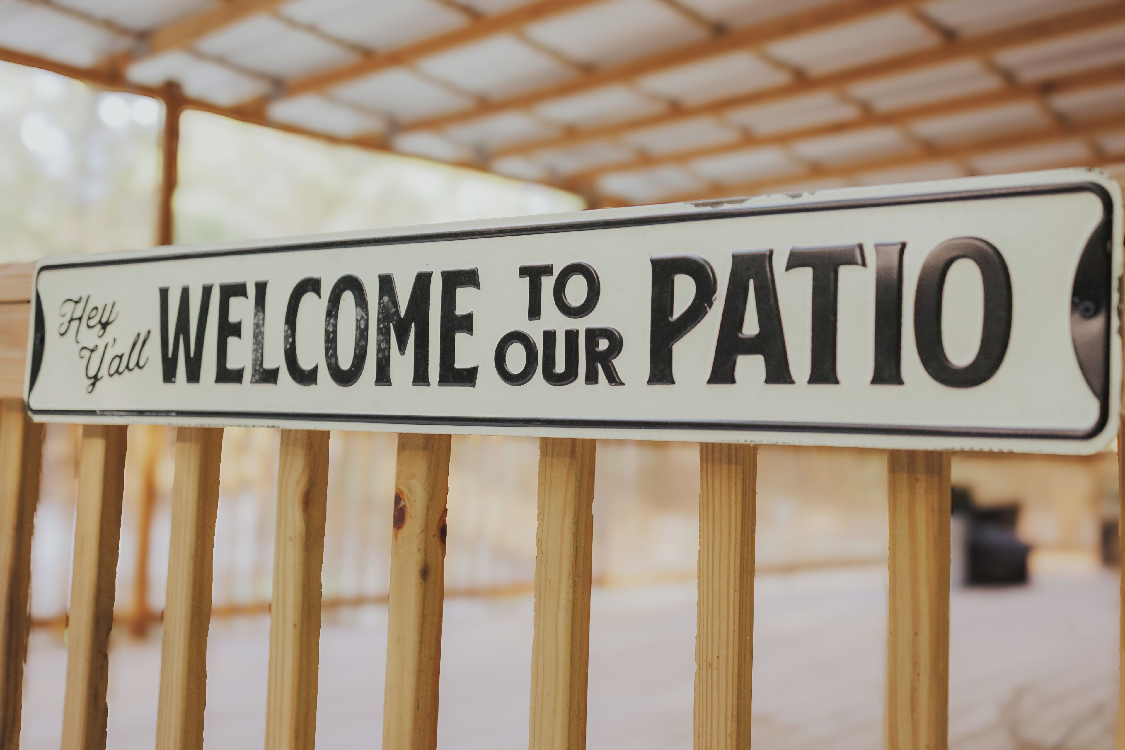 Une pancarte portant l’inscription « Bienvenue sur notre terrasse » est fixée à un poteau en bois.