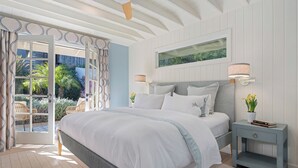 Een slaapkamer met een bed, nachtkastjes, een raam en uitzicht op de omgeving.