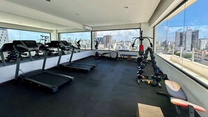Une salle de sport équipée de tapis de course, de vélos d’exercice et de matériel de musculation.