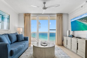 A room with a sofa, a coffee table, a TV, and a view of the ocean. - 🌅Stunning Gulf Front Views | 3 Pools | Pelican Beach 1912🌅 (Destin)