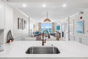 A modern kitchen with a large island, a view of the ocean, and a dining area with a view. - 🌅Stunning Gulf Front Views | 3 Pools | Pelican Beach 1912🌅 (Destin)