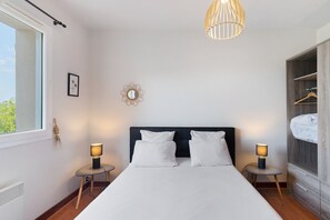 A bedroom with a bed, two bedside tables, a hanging light fixture, a framed picture, and a wardrobe. - Gîte l'Envie Périgord Noir – Peaceful Home with Pool near Lascaux (Montignac-Lascaux)