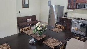 Cocina compacta con refrigerador, microondas y estufa.