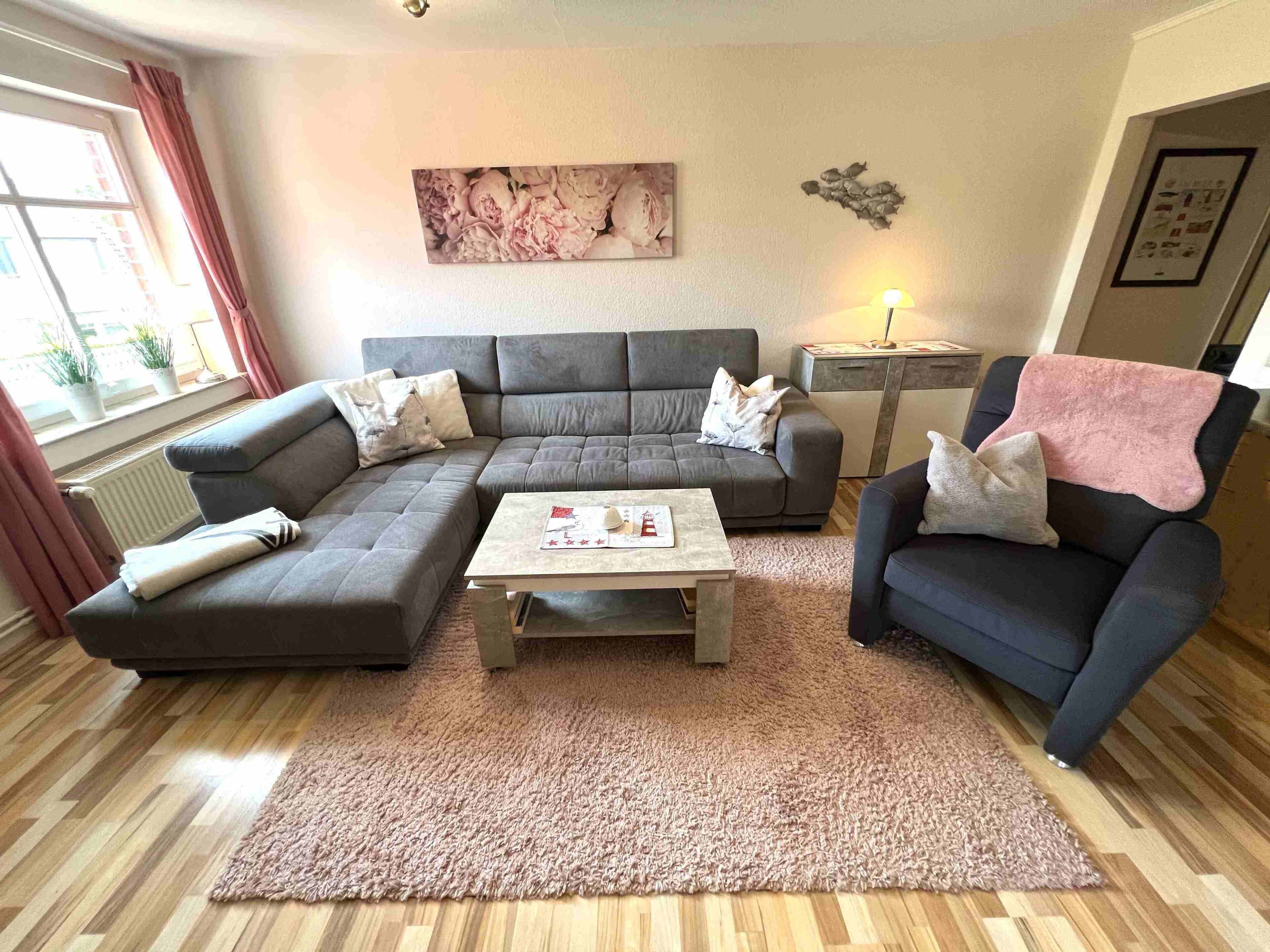 Ein Wohnzimmer mit einer Eckcouch, einem Couchtisch und einem kleinen Beistelltisch.