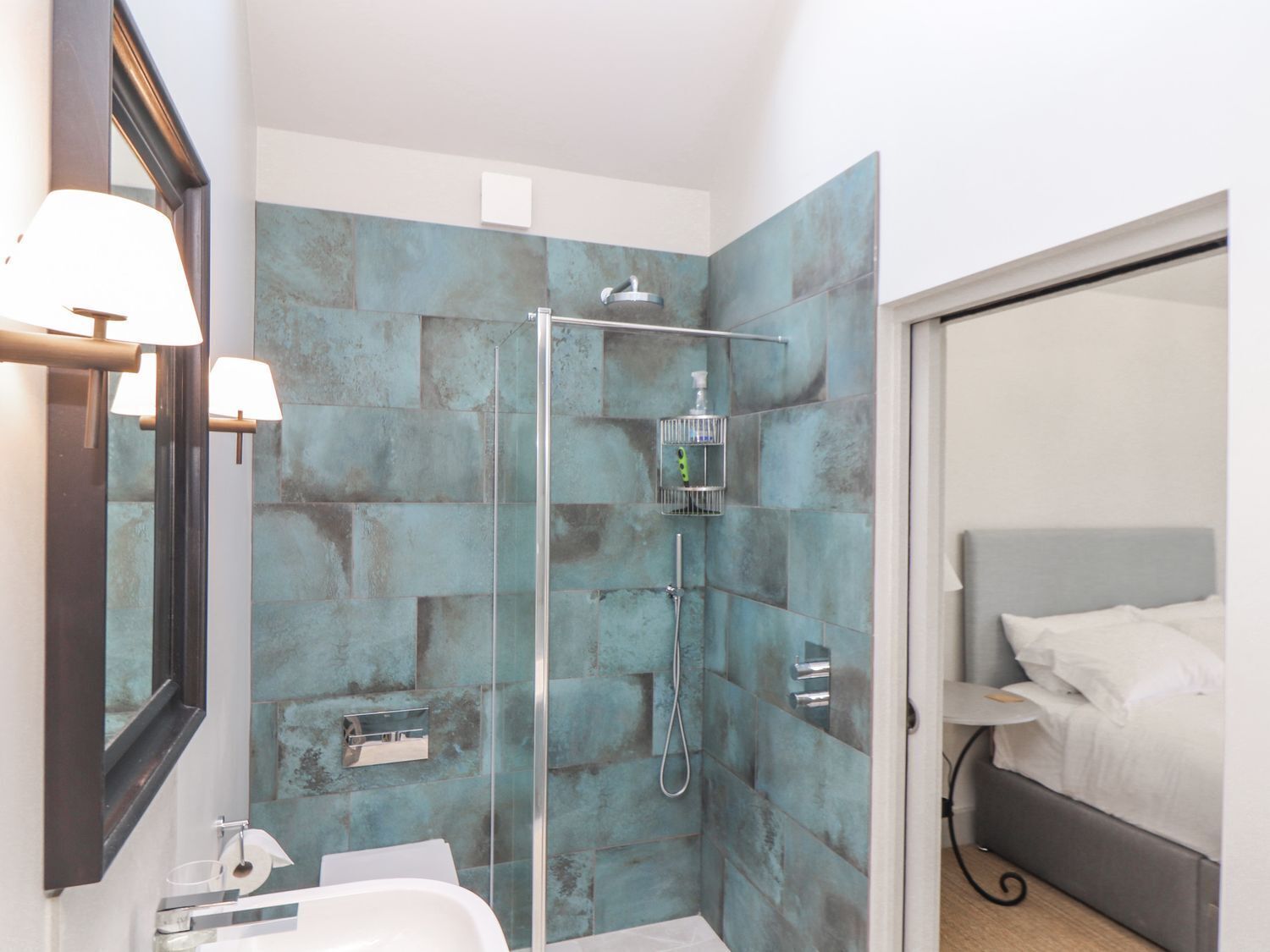 Une salle de bain moderne avec une douche à parois de verre, un lavabo et un miroir.