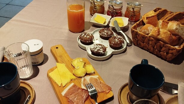 Een ontbijtbuffet met diverse gerechten, bestek en toevoegingen.