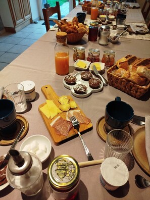 A breakfast buffet with various food items, utensils, and condiments. - Château Besson (Désertines)
