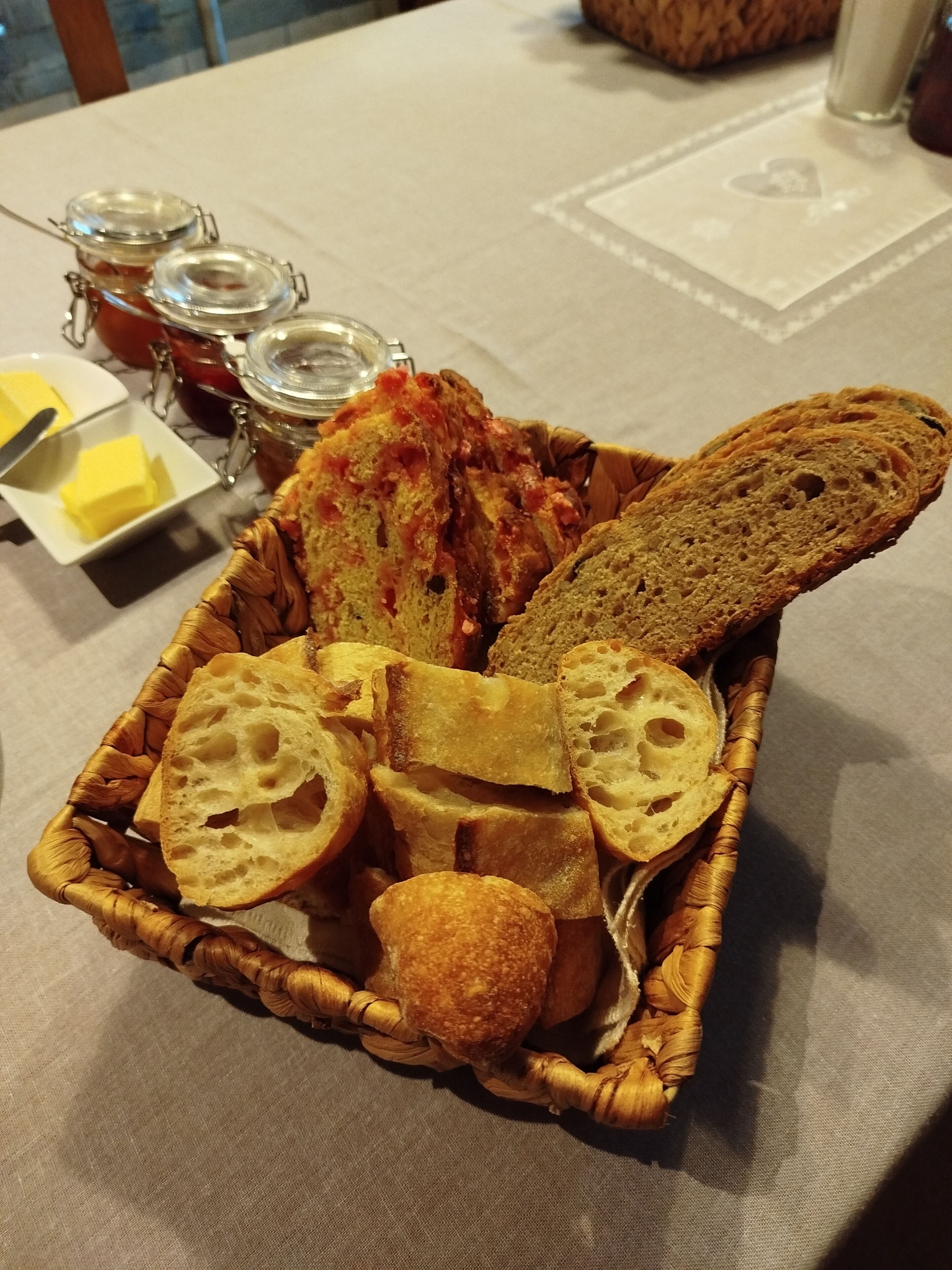 A basket of bread and butter on a table.