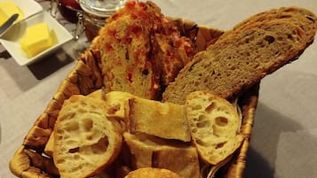 A basket of bread and butter on a table.