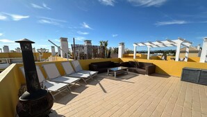Terraza en la azotea con sillones, un sofá y una mesa.