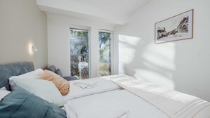 Une chambre à coucher avec un lit, une fenêtre et un tableau encadré au mur.