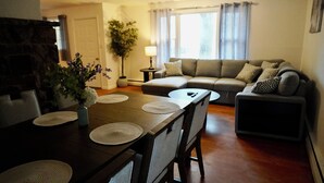 En matplats med ett träbord, stolar och en vas med blommor.