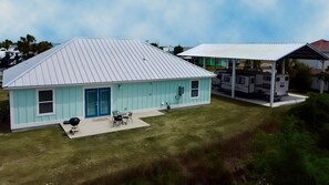 Single-story home exterior with a back patio and an adjacent covered carport for an RV. - The Rusty Pelican -Boat-Jet ski parking available (Mexico Beach)