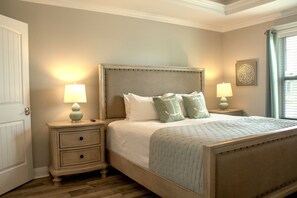 A cozy bedroom with an upholstered wood-framed bed and matching nightstands. - The Rusty Pelican -Boat-Jet ski parking available (Mexico Beach)