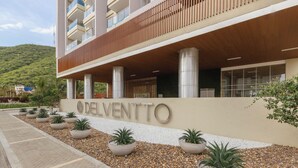 A modern hotel with a prominent 'Delvento' sign, large columns, and potted plants along the entrance. - Edificio Delventto cerca a la Playa Cabo Tortuga (Santa Marta)