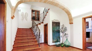 Eine Treppe mit schmiedeeisernem Geländer, das zu einer Zwischenebene führt.