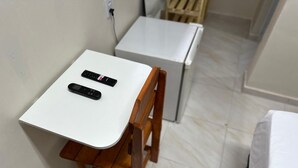 A small wooden chair with a white table, a black remote control, and a white appliance in the background. - Aeroconforto Residential - Near the Airport and Factories in Tarumã - Room 2 (Manaus)