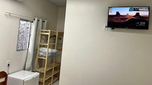 A room with a bunk bed, a small desk, a wall-mounted TV, and an air conditioning unit. - Aeroconforto Residential - Near the Airport and Factories in Tarumã - Room 2 (Manaus)