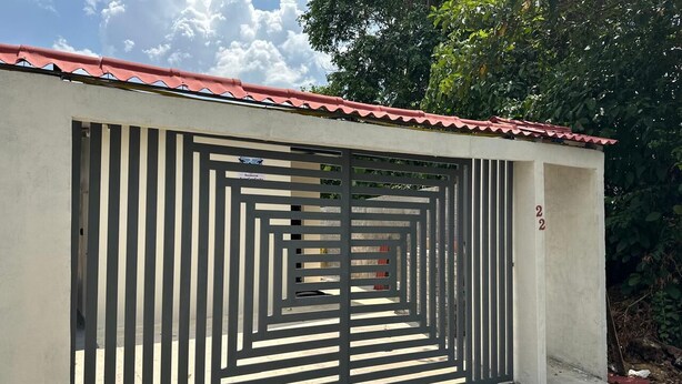 A gated building with a red roof and a barred entrance. - Aeroconforto Residential - Near the Airport and Factories in Tarumã - Room 2 (Manaus)