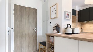 Une cuisine moderne avec un plan de travail en bois, un petit tabouret et une bibliothèque.