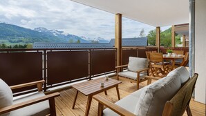 Un balcon agrémenté de meubles en bois, d’une table et de chaises.