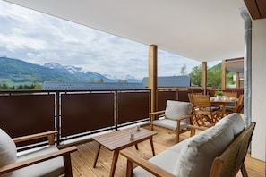 Un balcone con mobili in legno, un tavolo e sedie.