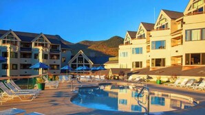 Et hotel med poolområde, flere balkoner og en restaurant.
