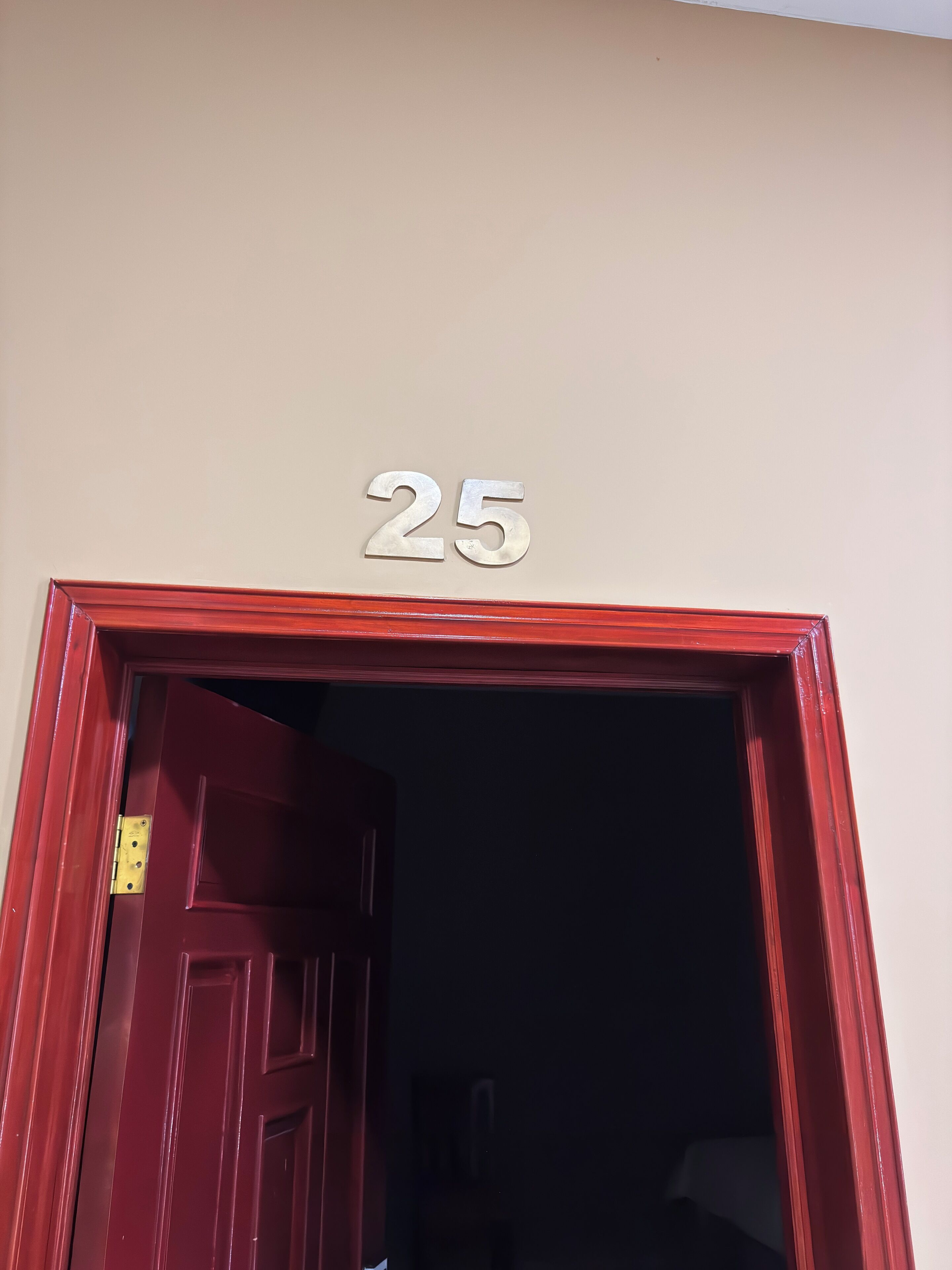 A red door with a number '25' above it, indicating a room number.