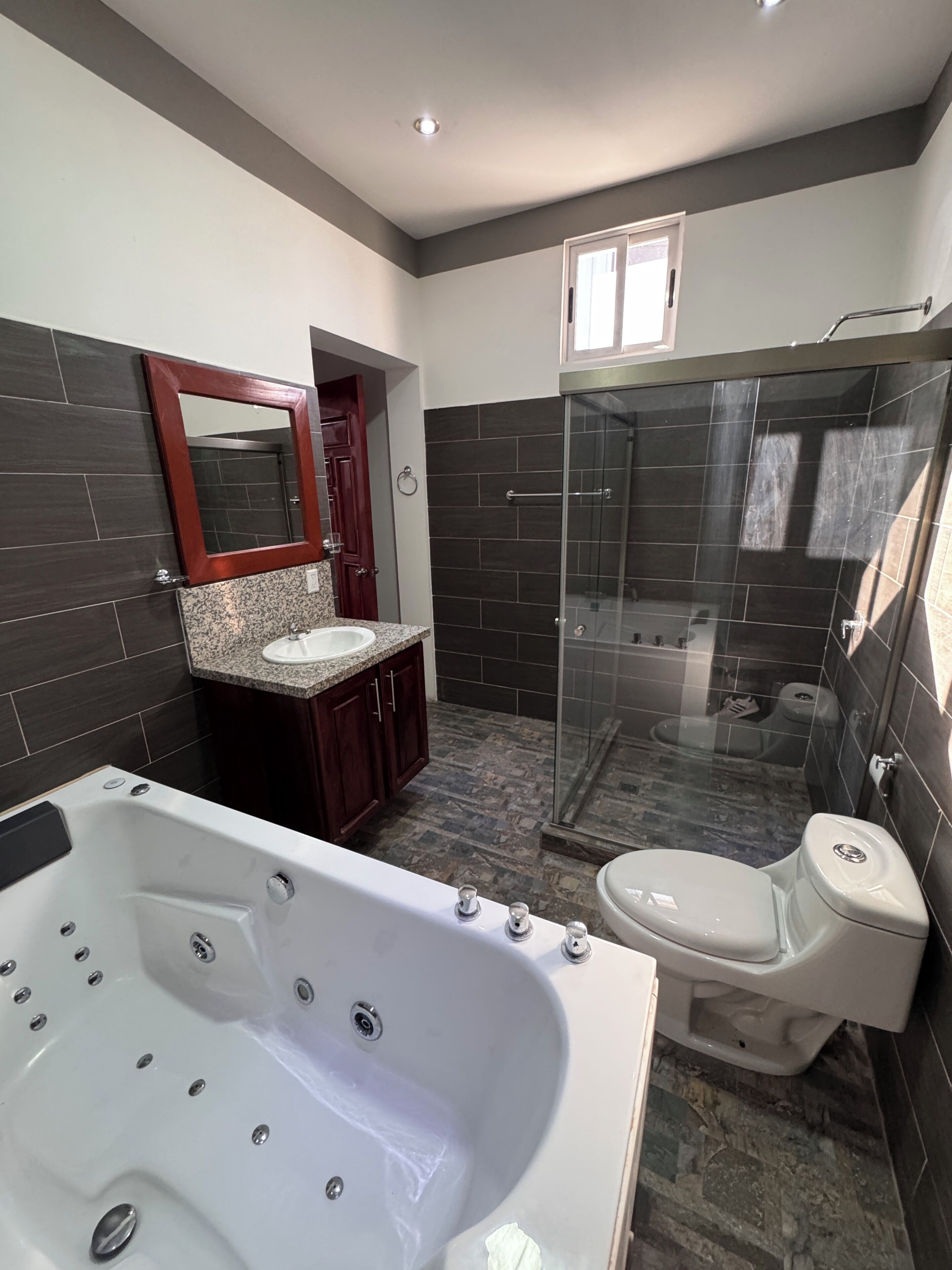 Une salle de bain moderne avec une baignoire, des toilettes et une douche  à parois de verre.