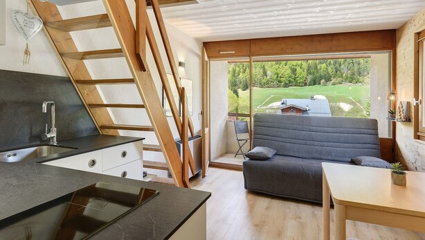 A modern kitchen with a built-in stove, a dining area with a table and chairs, and a cozy seating area with a sofa and a view of the outdoors. - Elegant 'Havre de Paix' Apartment with Mountain View, Private Terrace & Wi-Fi (Villard-de-Lans)
