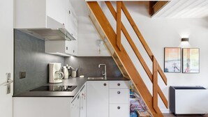 A modern kitchen with white cabinets, a stainless steel sink, and a coffee maker. - Elegant 'Havre de Paix' Apartment with Mountain View, Private Terrace & Wi-Fi (Villard-de-Lans)