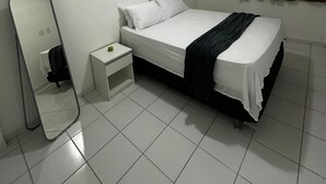 A bedroom with a bed, a nightstand, a mirror, and a window with curtains. - Apartment in the Green Tower Building (Maceió)
