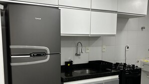 A modern kitchen with a refrigerator, stove, sink, and cabinets. - Apartment in the Green Tower Building (Maceió)