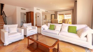 A living room with a sofa, two armchairs, a coffee table, and a staircase. - Holiday Home 'Ses Gavines en Cala Moragues' with Sea View, Wi-Fi and Air Conditioning (Andratx)