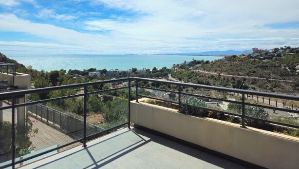 Un balcón con vista al mar y un paisaje montañoso.