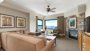A hotel room with a large sofa, a fireplace, a television, and a view of the mountains. - Mountain Villa w/ Fireplace near Heavenly (Stateline)