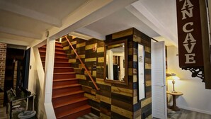 A staircase with a wooden design, a mirror, and a sign reading 'MANCAVE'.