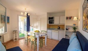 A compact living space with a dining area, kitchenette, and a sofa. - Apartment with pools and garden near the beach (La Baule-Escoublac)